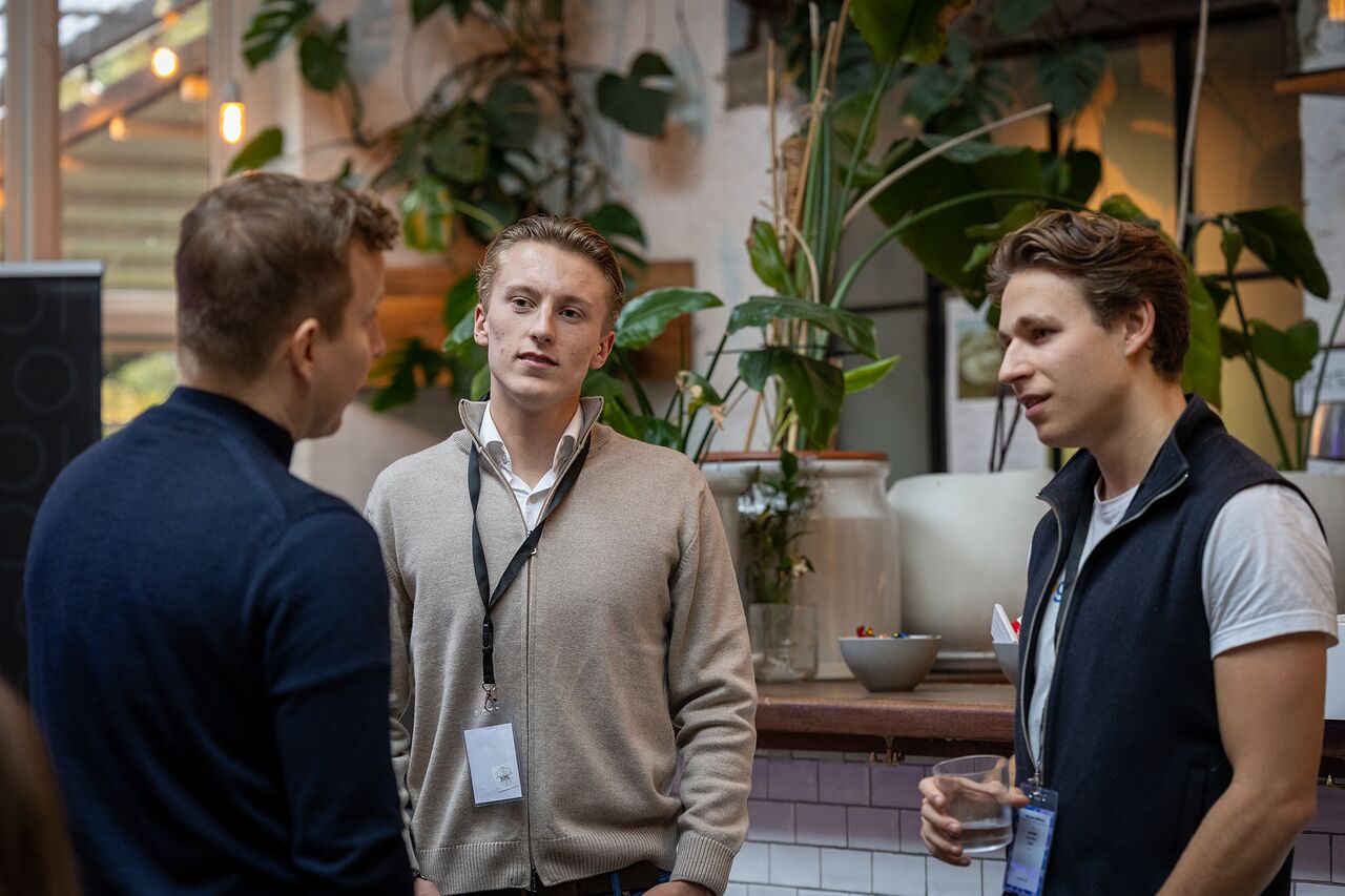 Three attendees talking among the plants in the bar
