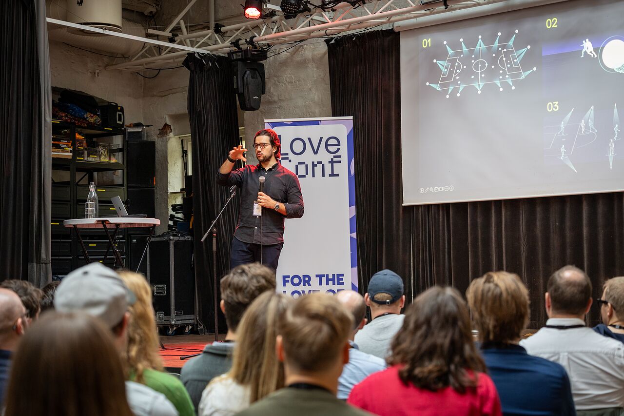A speaker with a microphone next to the LoveConf banner