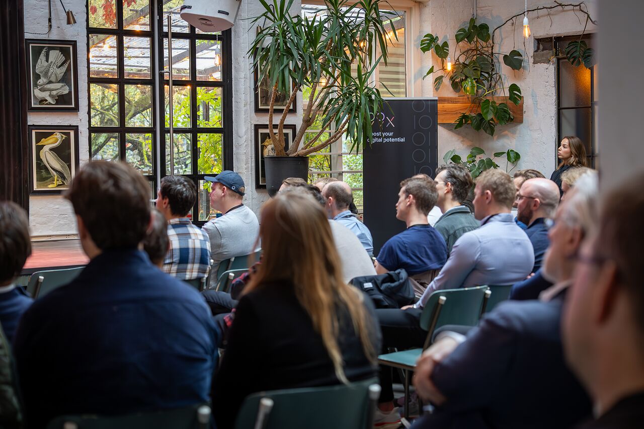The audience listening, seen from the side of the room