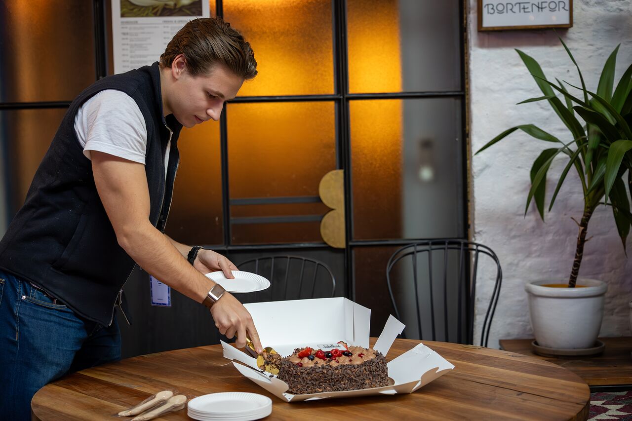 An attendee cutting the cake in the break