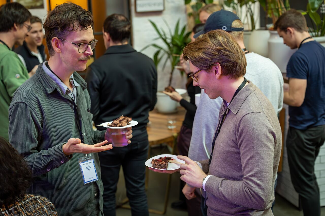 Two attendees talking over cake