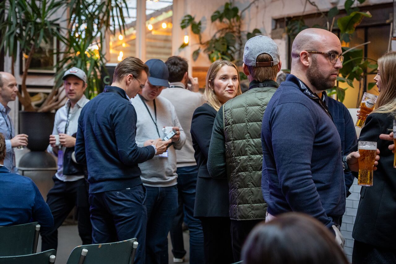 Attendees mingling with drinks in the break